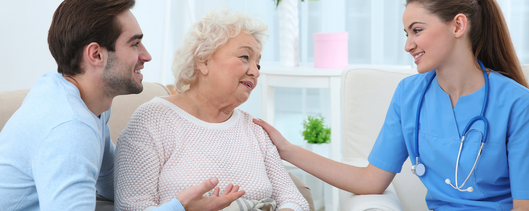 nurse talking with grandmother and her grandson indoors