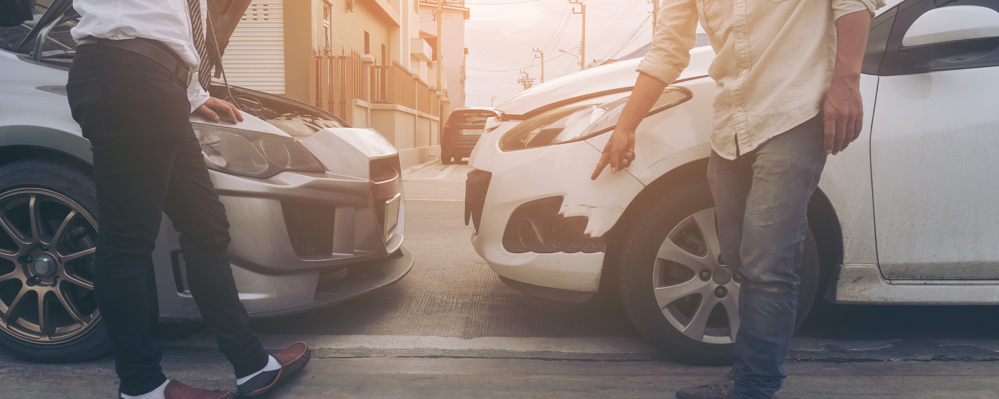 2 cars with minor damage parked on a street as drivers speak about accident - Pike County Auto Accident Lawyer concept image