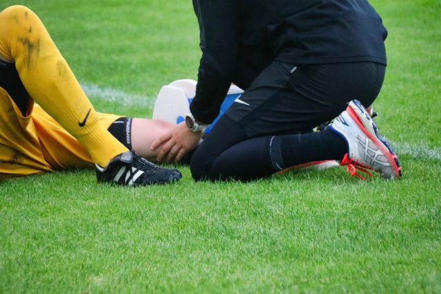 injured soccer player examined by trainer