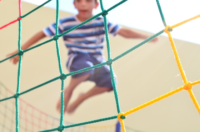 child jumping behind netting