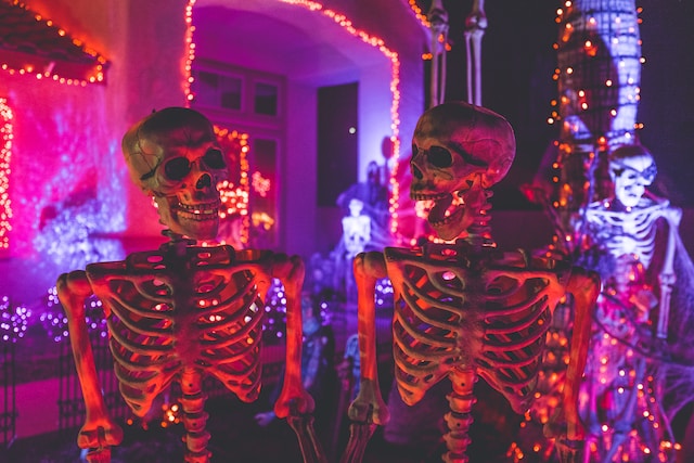 skeleton decorations in front of purple and orange lights