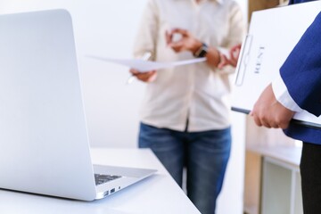 two people looking at documents and computer