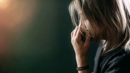 woman's side profile with hand to mouth