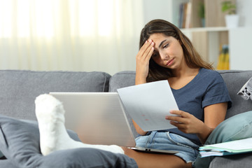 stressed woman with broken foot and papers