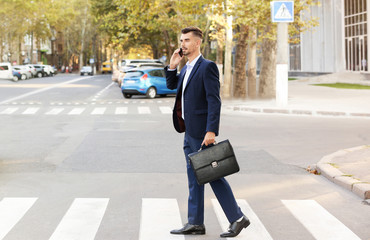 man crossing the street distracted on the phone