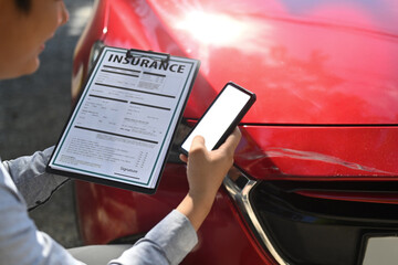 insurance adjuster with clipboard at car