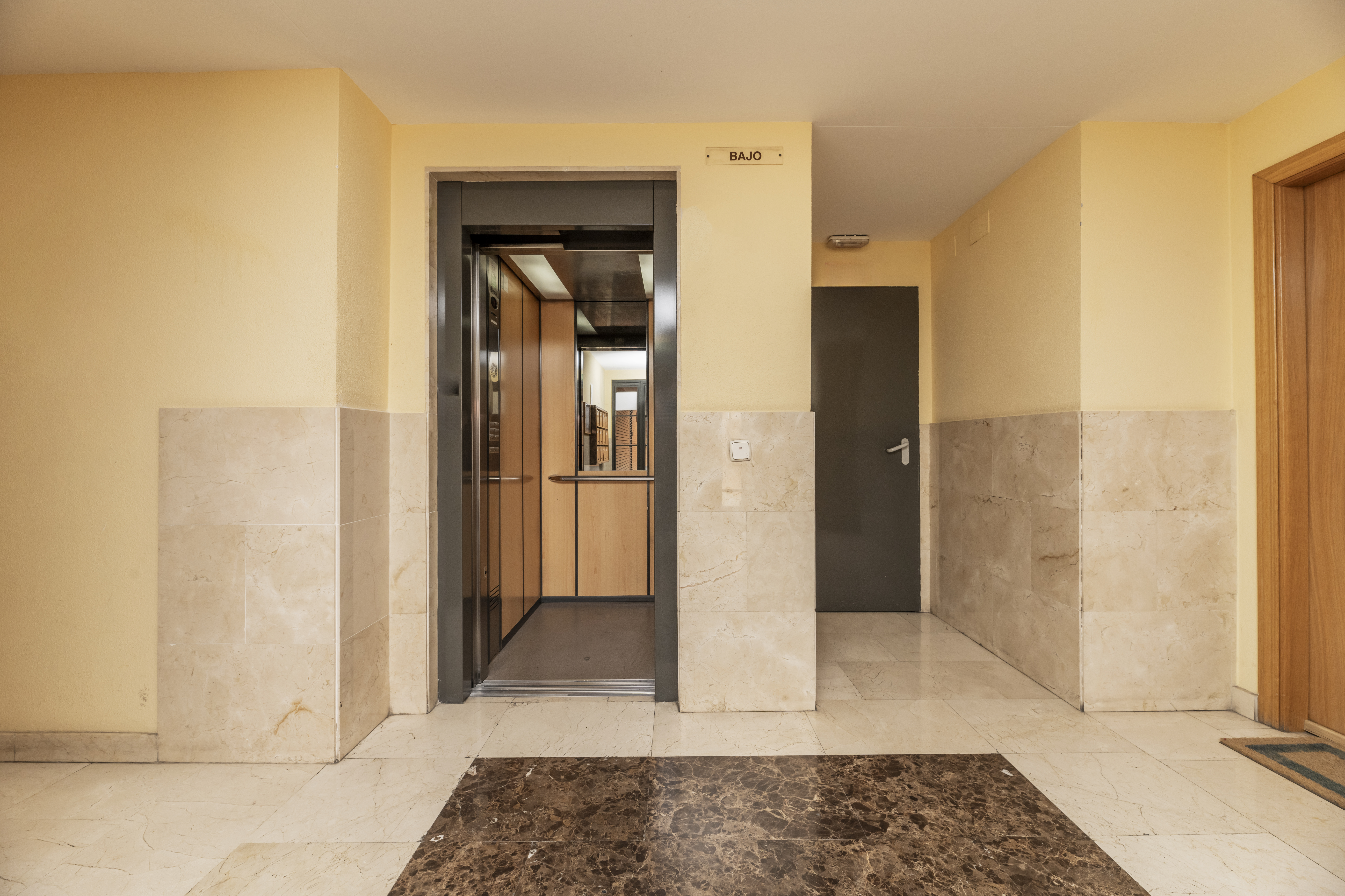 Portal of a residential apartment building with an elevator with solid gray painted doors